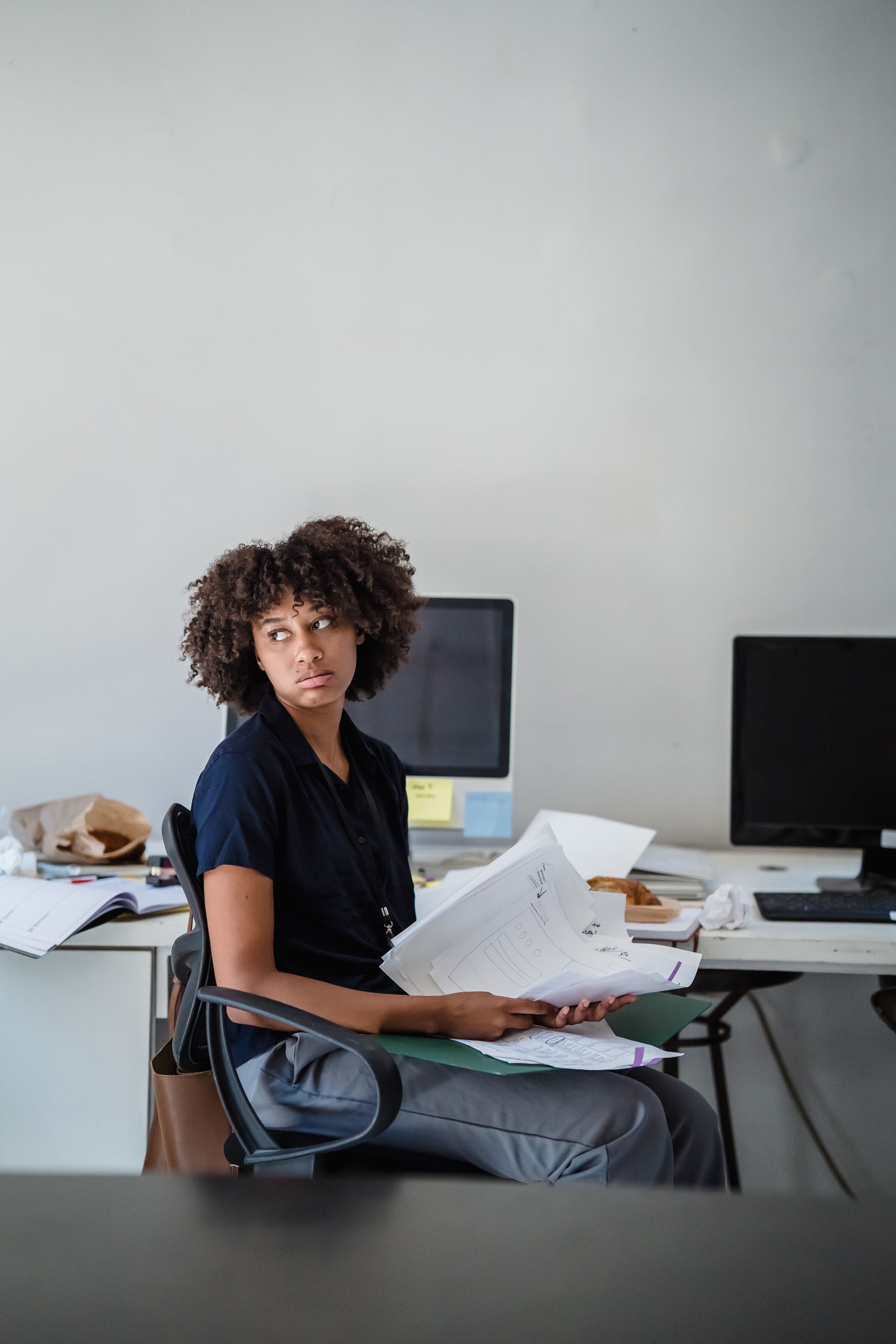 Responsable associative se retournant, un dossier de documents dans les mains